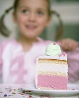 Mädchen mit einem Stück bunter Geburtstagstorte