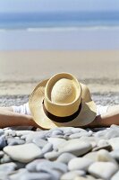 Man in hat lying on beach