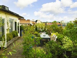 Üppig bepflanzte Dachterrasse mit Tisch & Stühlen