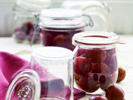 Red gooseberry compote in preserving jars