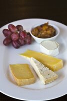 Cheese plate with grapes and pickles