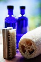 Two blue glass bottles, sponge and brush in the bathroom