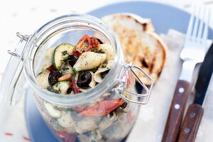 Pasta salad with olives, tomatoes and courgette for a picnic