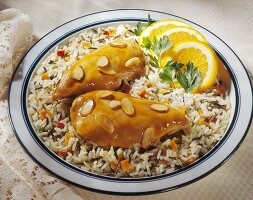Orange-glazed chicken breasts with almonds on bed of rice