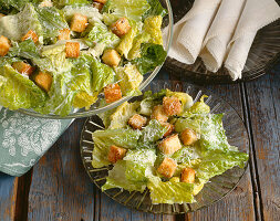 Caesar Salad in einer Schüssel und auf Teller