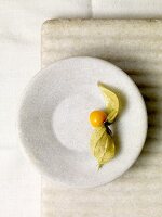 Single Gooseberry with Leaves on a Plate