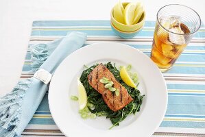 Grilled Salmon over Spinach with Lemon Wedges; Glass of Iced Tea