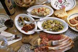 Gedeckter Tisch mit Antipasti und Rotwein, Toskana