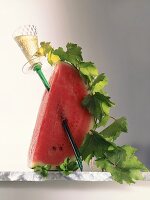 Wassermelone mit Weinglas und Weinranke