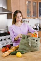 Woman Unloading Groceries from Cloth Bag on Kitchen Counter