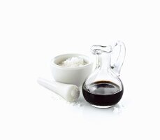 Coarse sea salt in a mortar and a carafe of balsamic vinegar