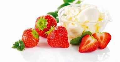 A bowl of vanilla ice cream and fresh strawberries