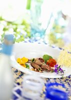 Rolls of young venison with nasturtium flowers