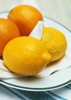 Two lemons and two oranges on a plate