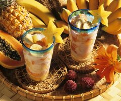 Exotic fruit salad with coconut milk in two glasses