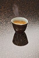 A cup of coffee on a background of coffee beans
