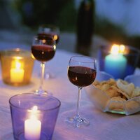 Tisch mit Rotweingläsern & Chips im Kerzenlicht