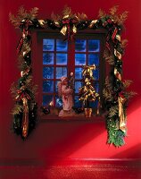 Weihnachtliche Girlande umrahmt das Fenster, Engel auf Fensterbrett