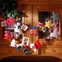 Girlande aus weihnachtlichen Stofffiguren am Schrank