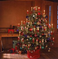 Bunt geschmückter Weihnachtsbaum mit bunten Kerzen