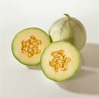 Eine ganze und eine halbierte Charentais-Melone