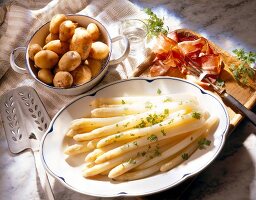 Asparagus with potatoes and ham in serving tray