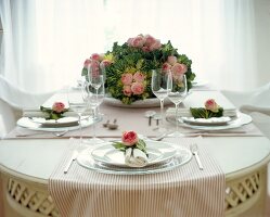 Gedeckter Tisch mit Zierkohl-/Rosen- Dekoration