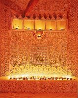 Wand mit indischer Ton-Stukkatur, von vielen Kerzen beleuchtet