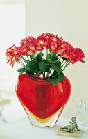 Red roses in heart shaped designer vase