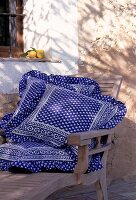 Blaue Kissen mit provencalischem Dessin schmücken einen Liegestuhl