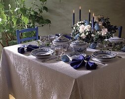 Gedeckter Tisch mit weißer Tischdecke und blau-weißem Geschirr
