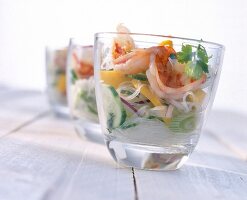 Noodles with shrimp and mango slices served in glasses