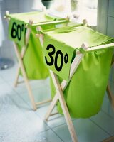 Close-up of two wooden drying rack with green laundry bags and temperature imprint