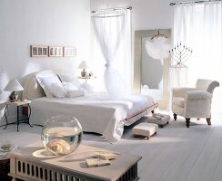 Interior of bedroom with white bed, chair, curtains and wall