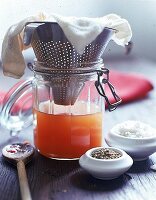 Tomaten-Essenz: Abseihen von Tomaten in ein Weckglas durch Sieb u. Tuch
