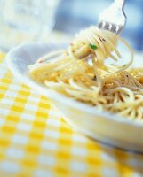 Ein Teller mit Spaghetti,werden auf eine Gabel gedreht, close up.