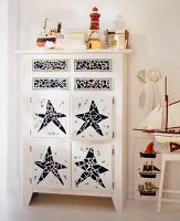 White chest of drawers decorated with tile shards