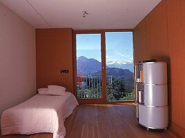 Puristisch möbliertes Schlafzimmer, gr. Fenster mit  Blick auf die Berge