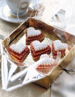 Heart shaped terrace cookies with raspberry jelly in golden box