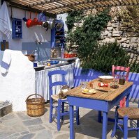 Terrasse eines Ferienhauses in Griechenland,blaue Bauernstühle u. Tisch