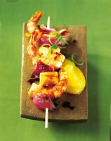 Close-up of skewers grilled with shrimp, mango and glazed onions
