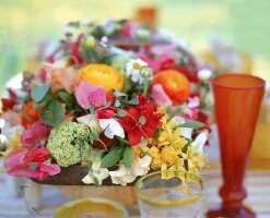 Arrangement aus Sommerblumen in einem Korb dient als Tischdekoration