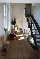 Hallway with pine floorboards and black metal staircase