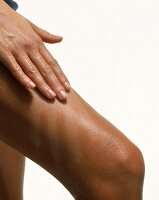 Beine mit Bräunungscreme gebräunt, heller Handabdruck auf dem Bein