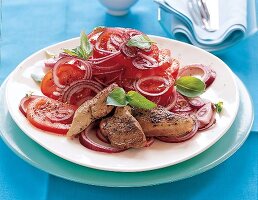 Tomatensalat mit roten Zwiebelringen und zarten Filetstückchen