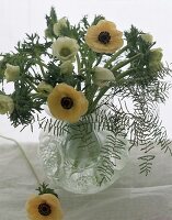 Zarte Annenmonen in weiß + gelb mit Farn in bauchiger Vase