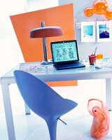 Laptop auf einem Schreibtisch mit einer Glasplatte, moderner Bürostuhl