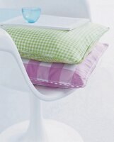Grünes und rosa Karokissen auf einem weißen Stuhl (3)