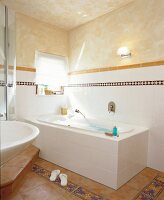 Terracotta Bad mit weißer Badewanne, Wand mit Bordüren,südl. Flair
