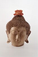 Buddha aus Speckstein geschnitzt mit Blütenschmuck